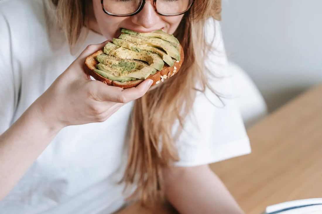 woman eating avocado on toast