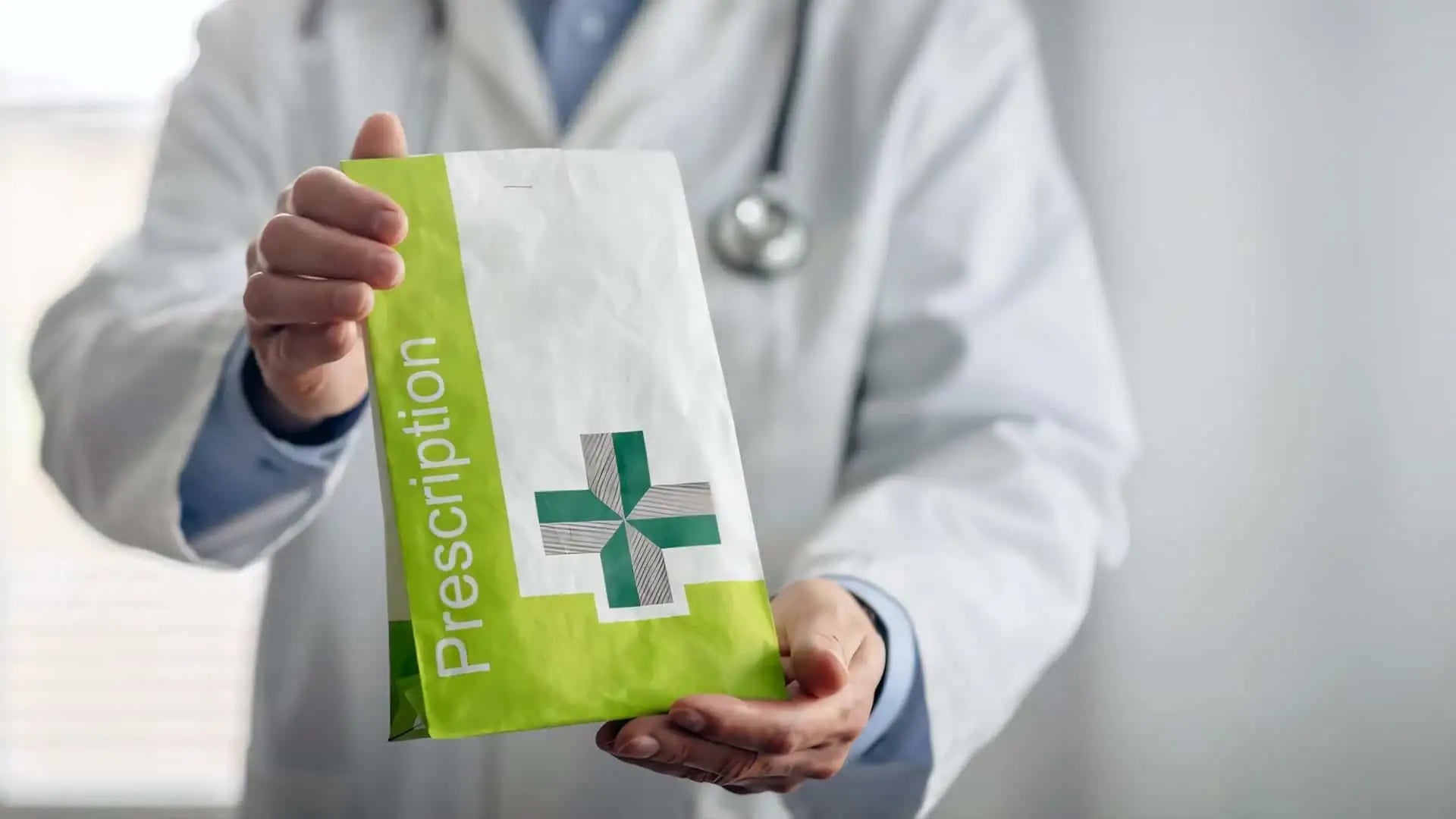 A white and lime green prescription bag with a prominent cross symbol.